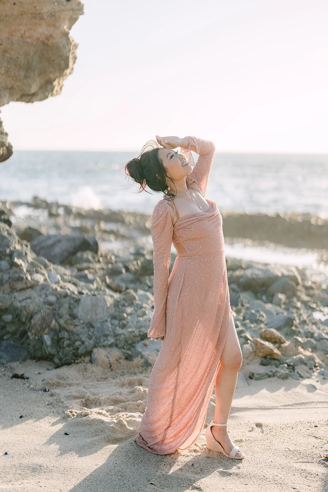 Amy posing on the rocks in her blush pink gown.