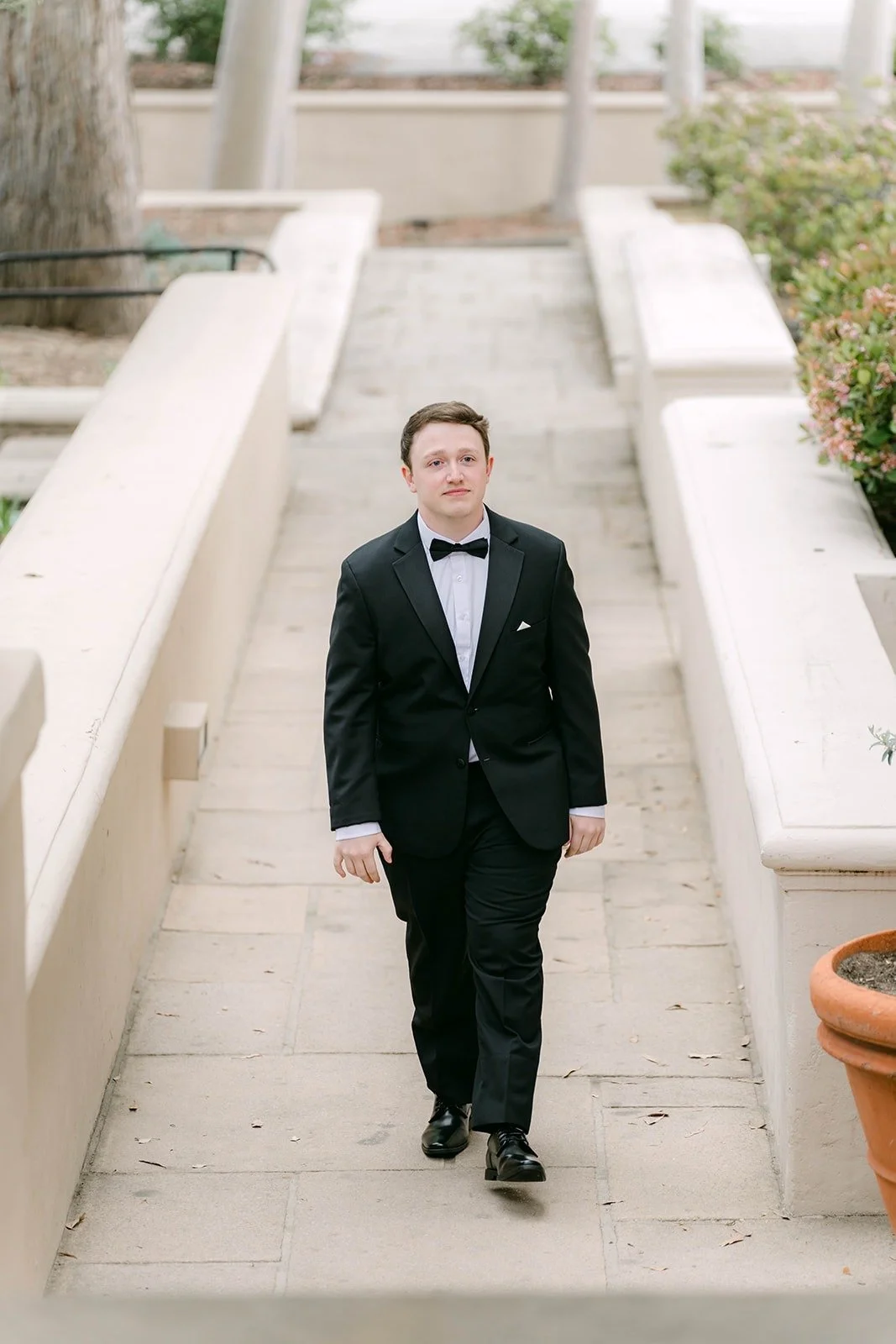 Matthew walking down the stone stairs toward the ceremony