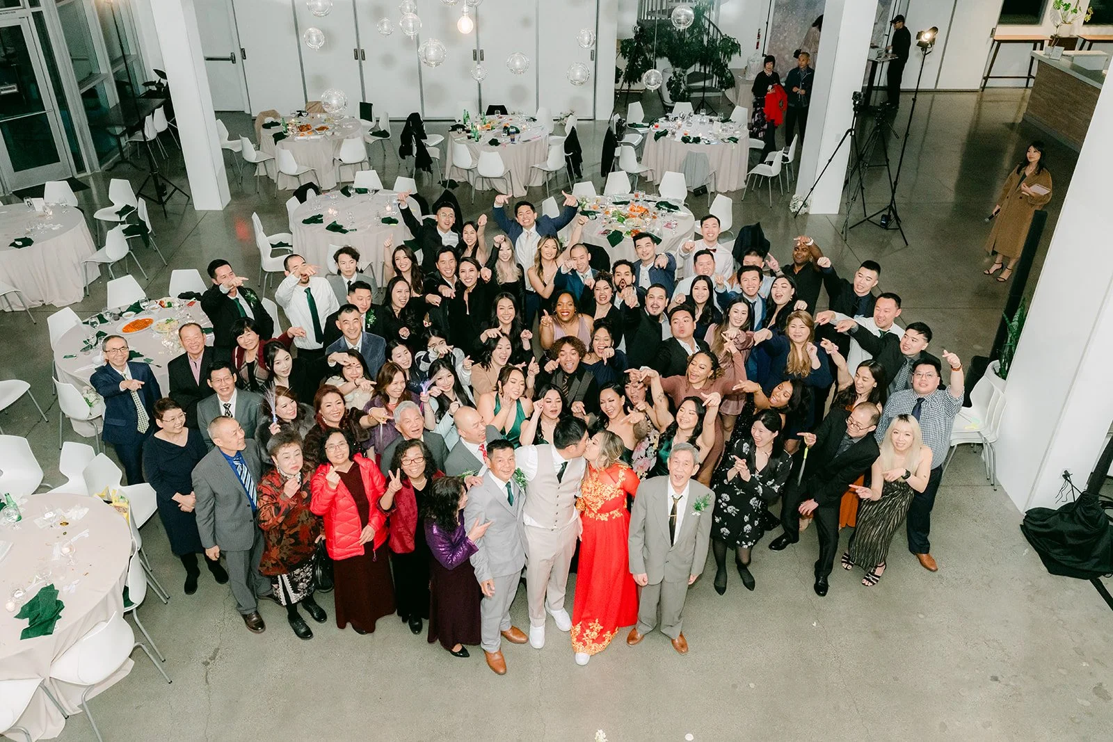 Wedding guests waving in a group photo from the balcony
