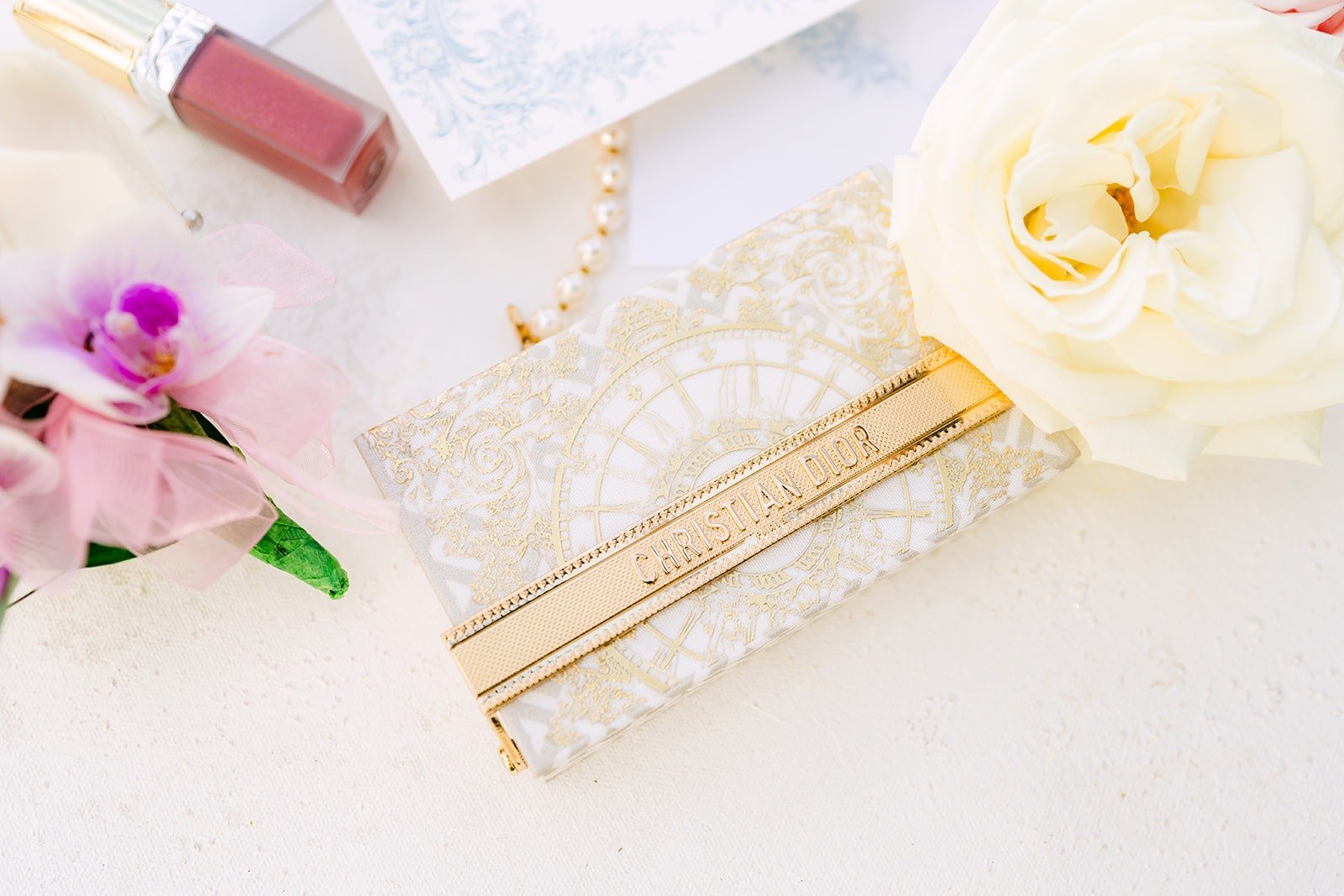 Gold clutch, lipstick and orchids from Ivy's wedding details