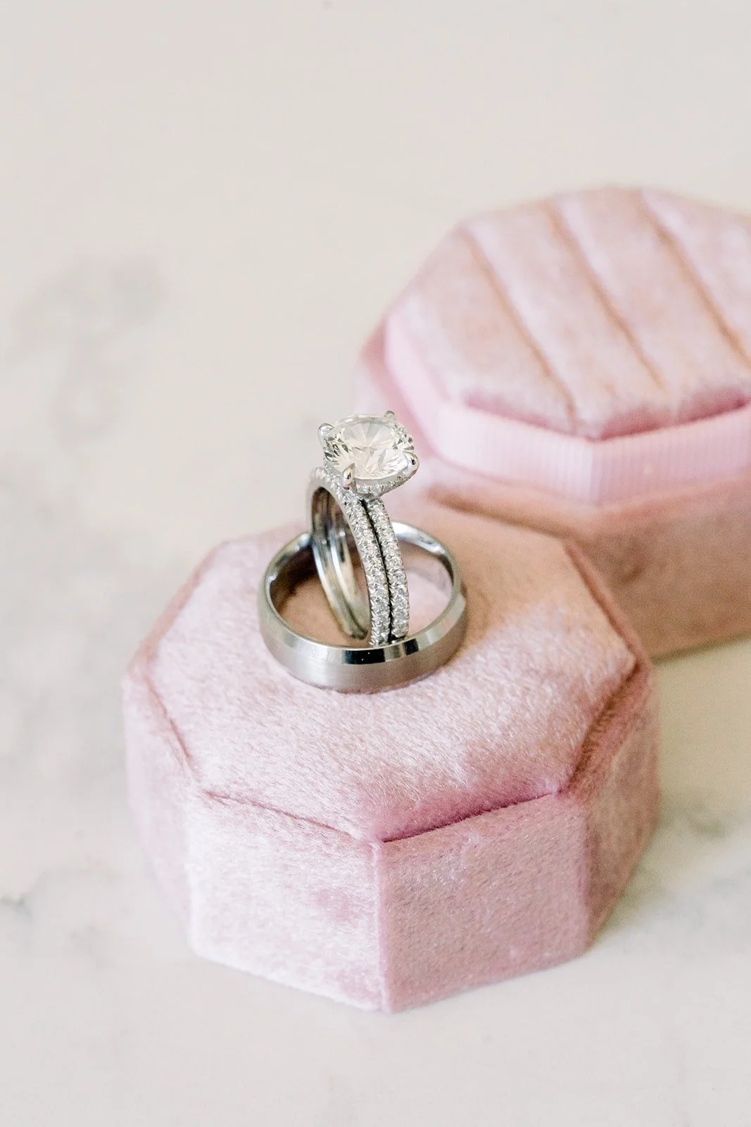 Wedding rings in a pink velvet ring box, photographed by One and Only Production