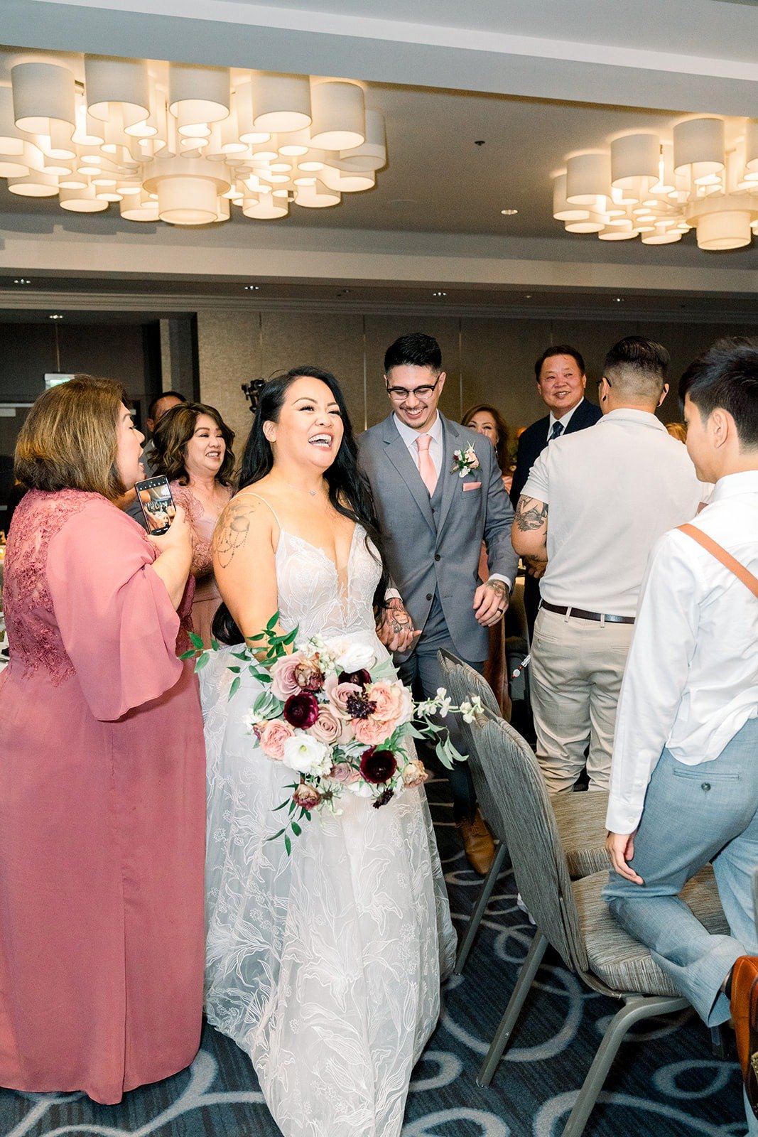 Betsy and Mikey walk in past cheering guests
