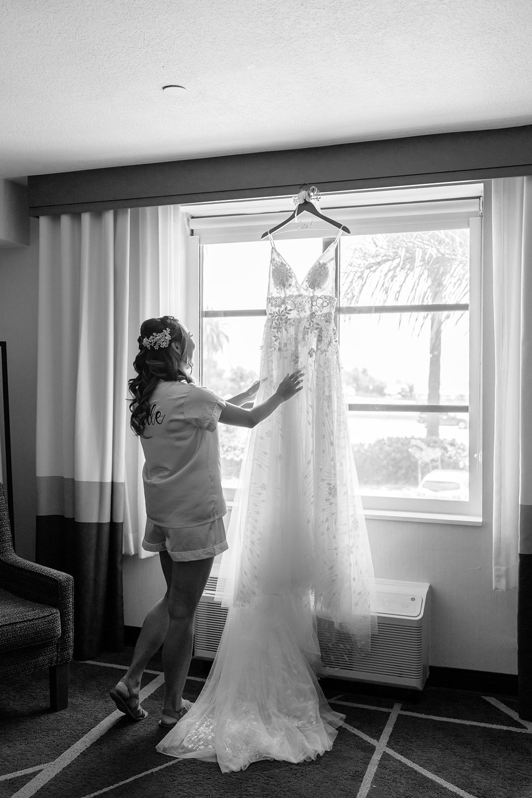 Ariel reaching for her gown by the window