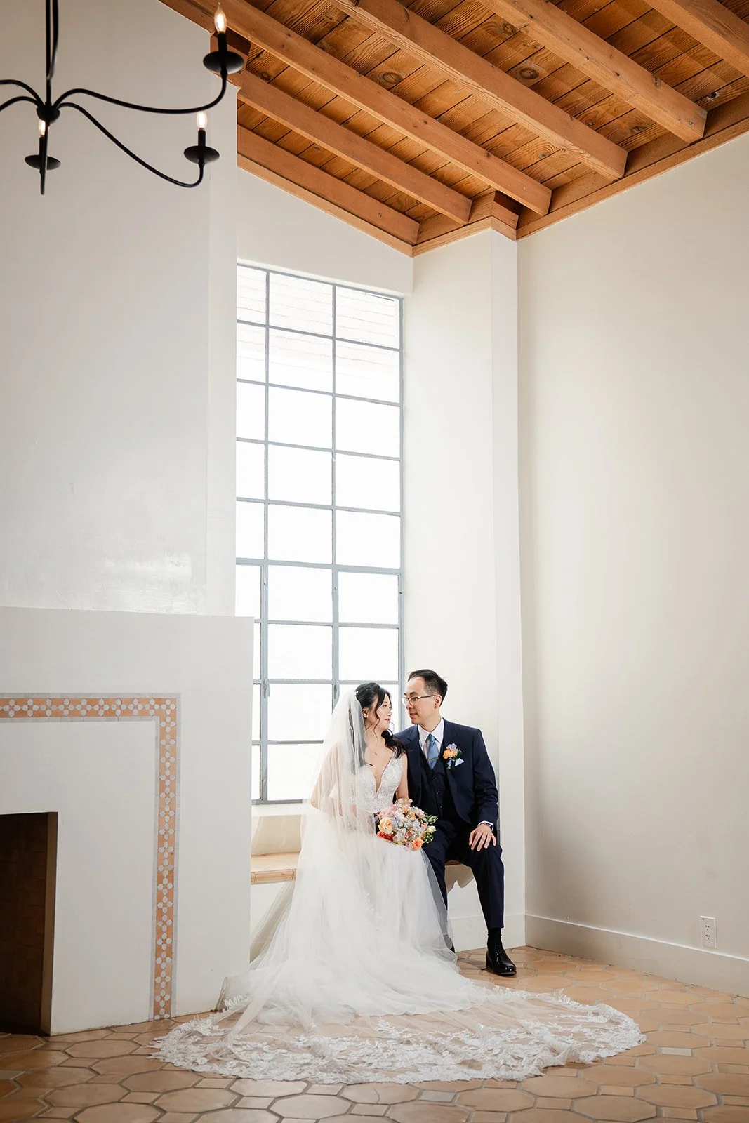 Couple seated by the tall windows of the hall