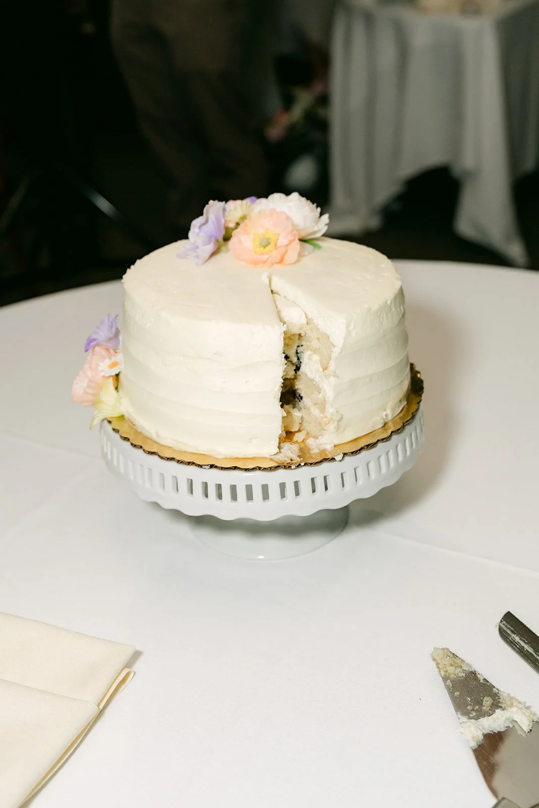 The sliced wedding cake with lavender florals