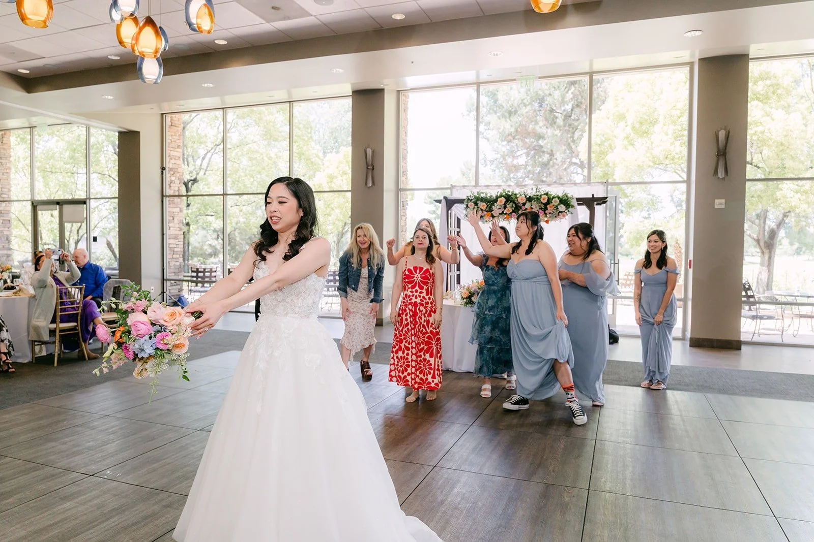 Natalie getting ready for the bouquet toss with guests lined up behind her