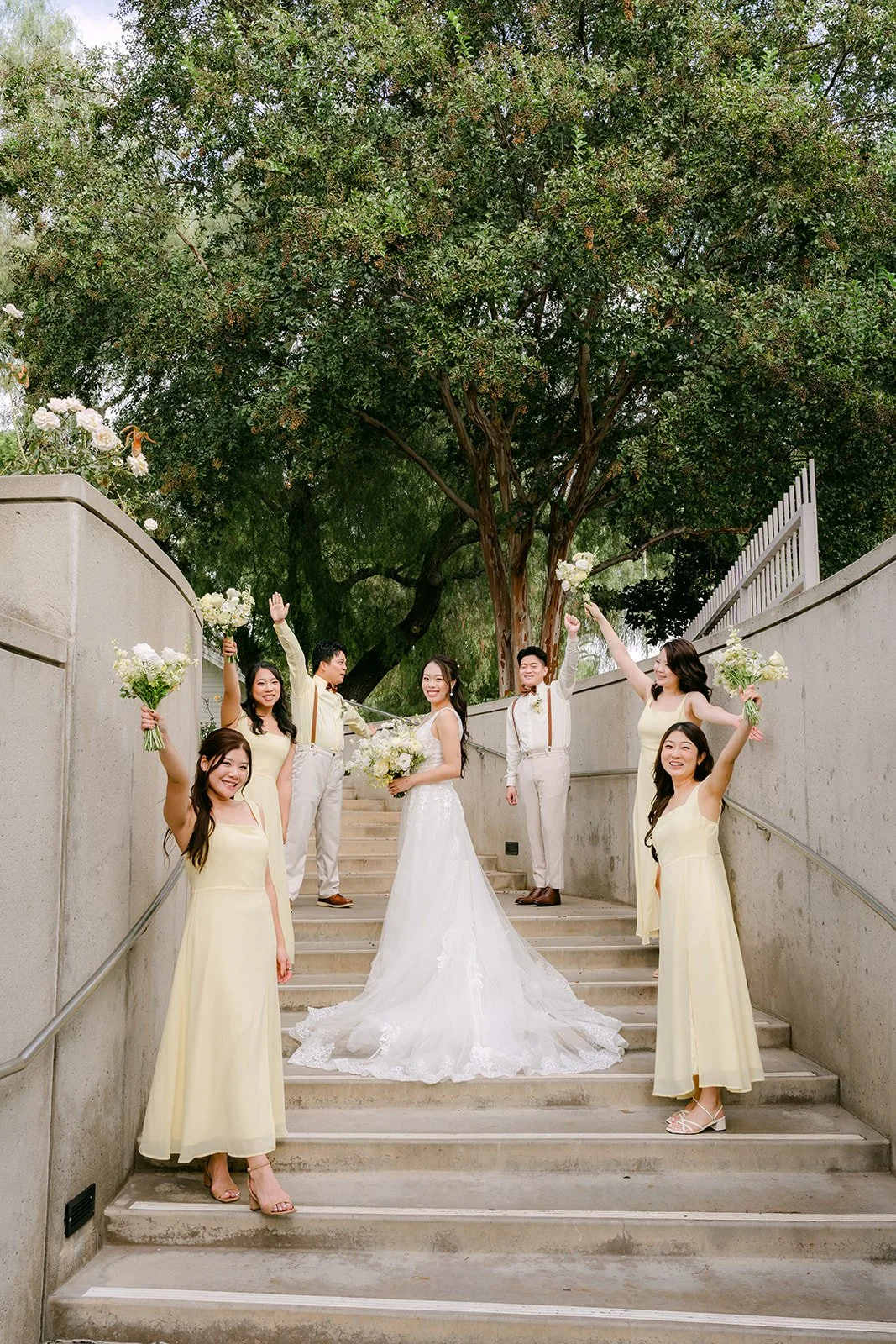 Jenny and her bridesmaids in butter yellow on the stone staircase.