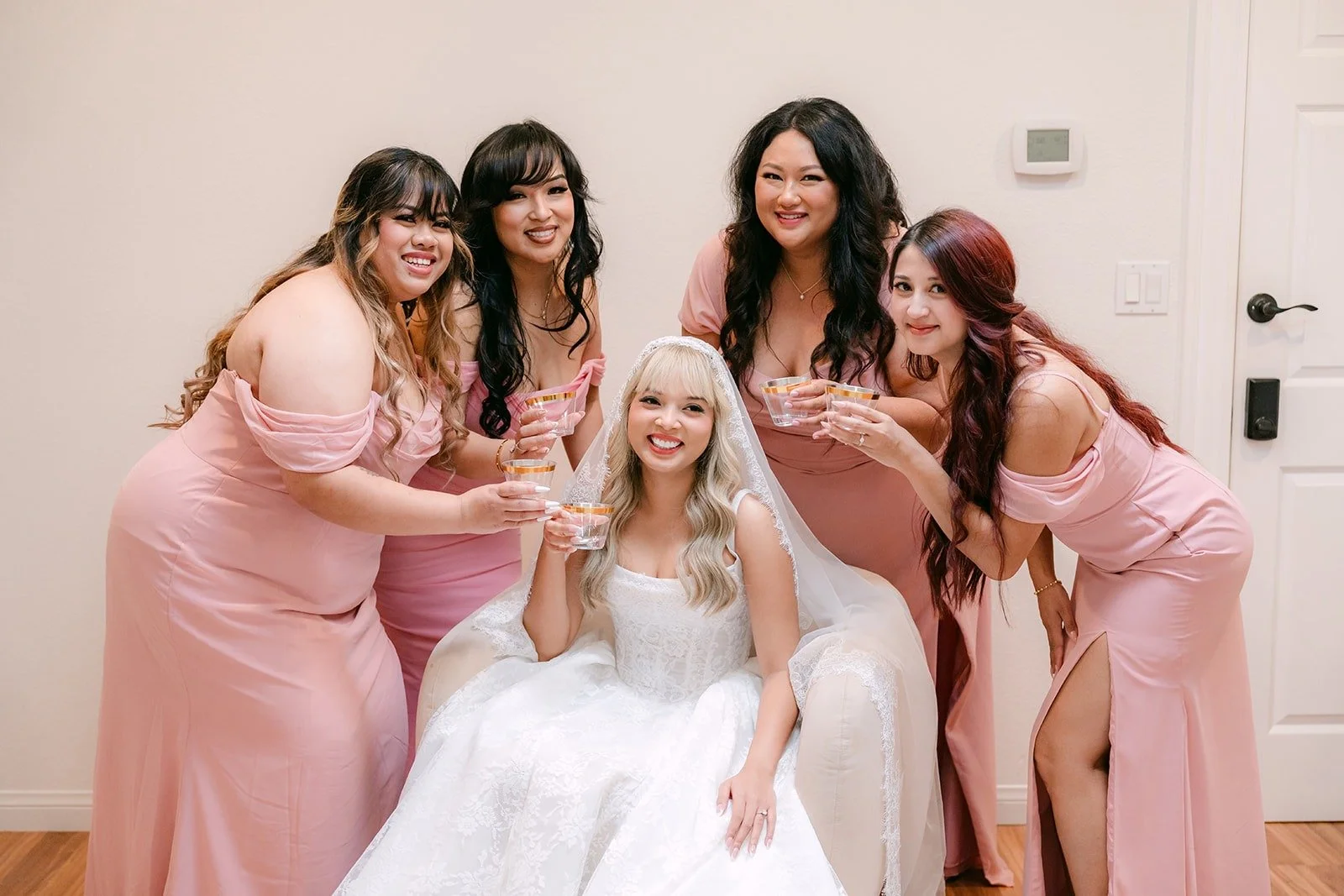 Konitha surrounded by her bridesmaids in dusty pink