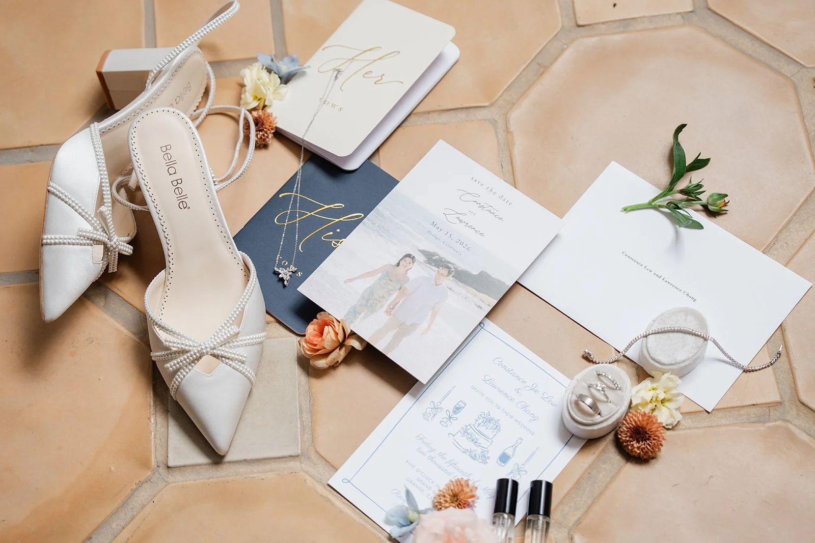 Bridal heels, rings and invitation laid out on the tile floor of the Grand Gimeno bridal suite