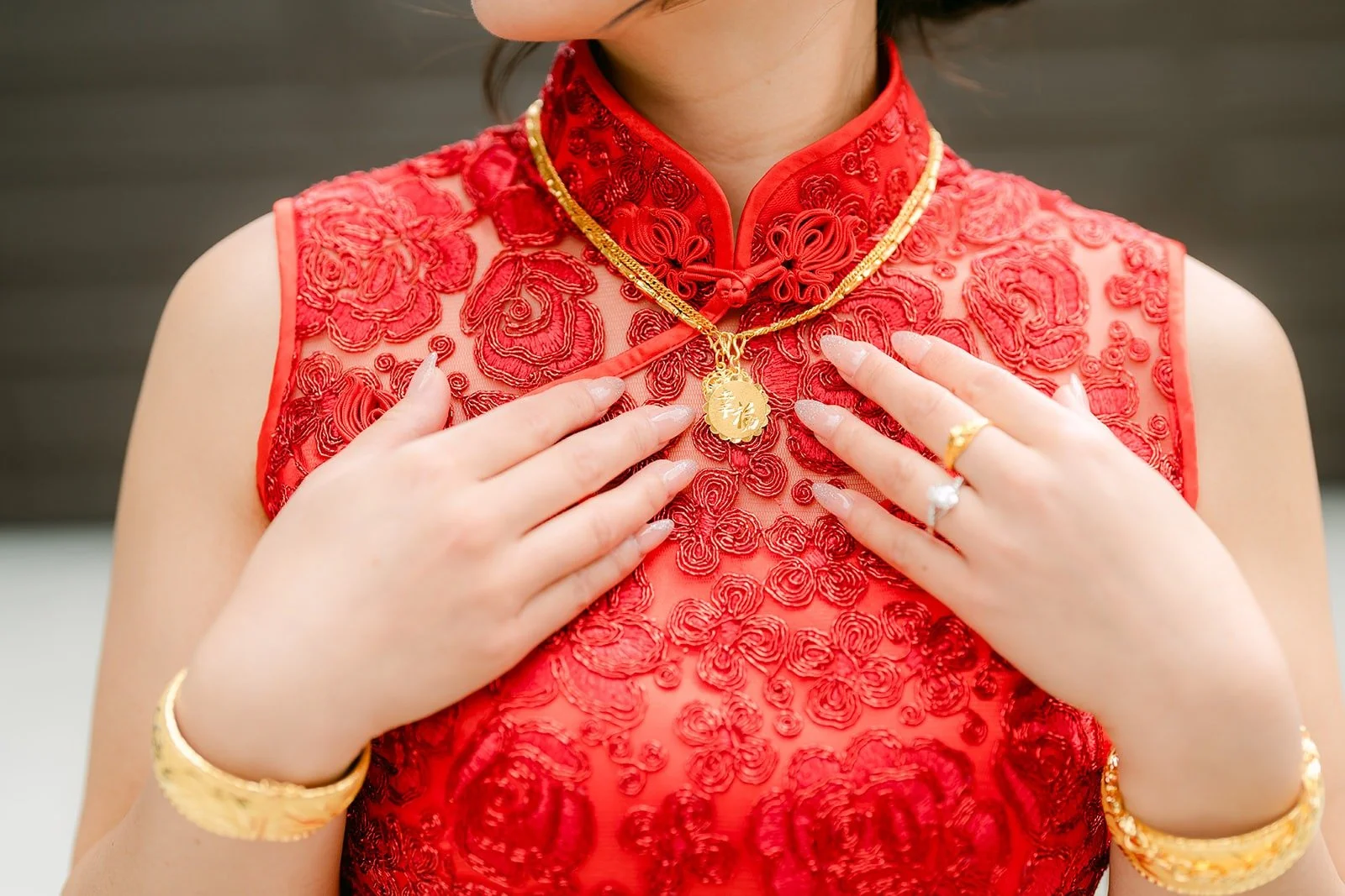 Close up of Xuemin's red lace cheongsam and gold necklace