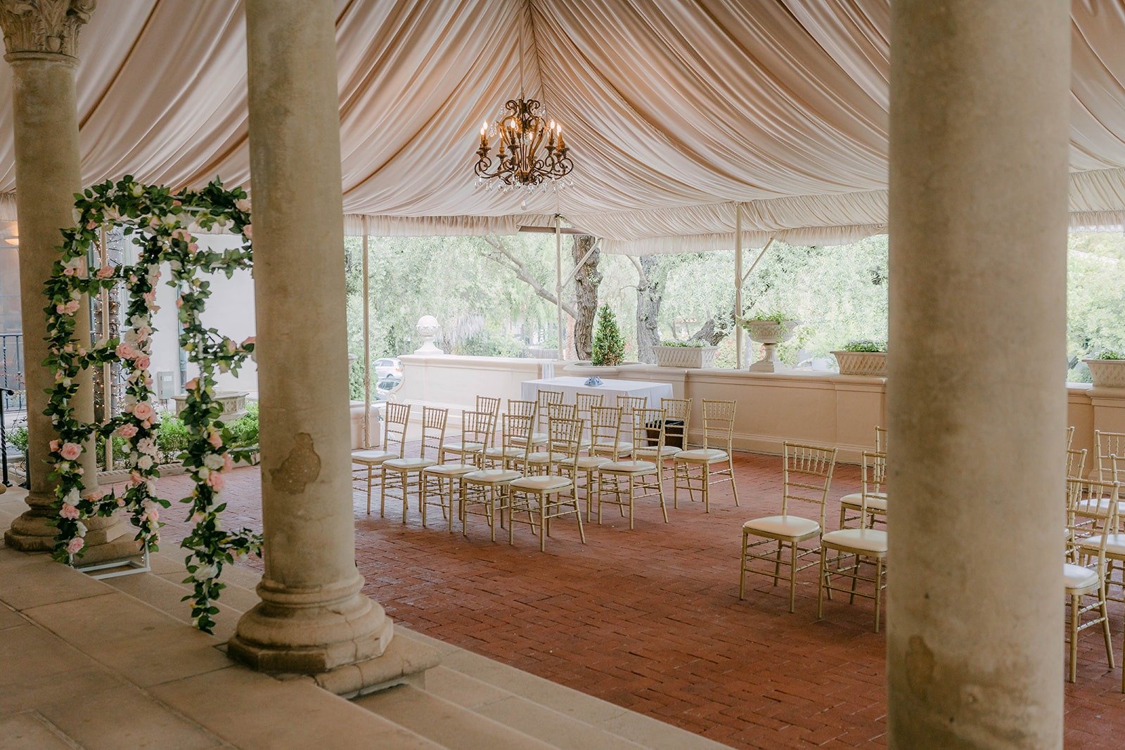 The ceremony aisle set with gold chairs between the columns of the East Patio
