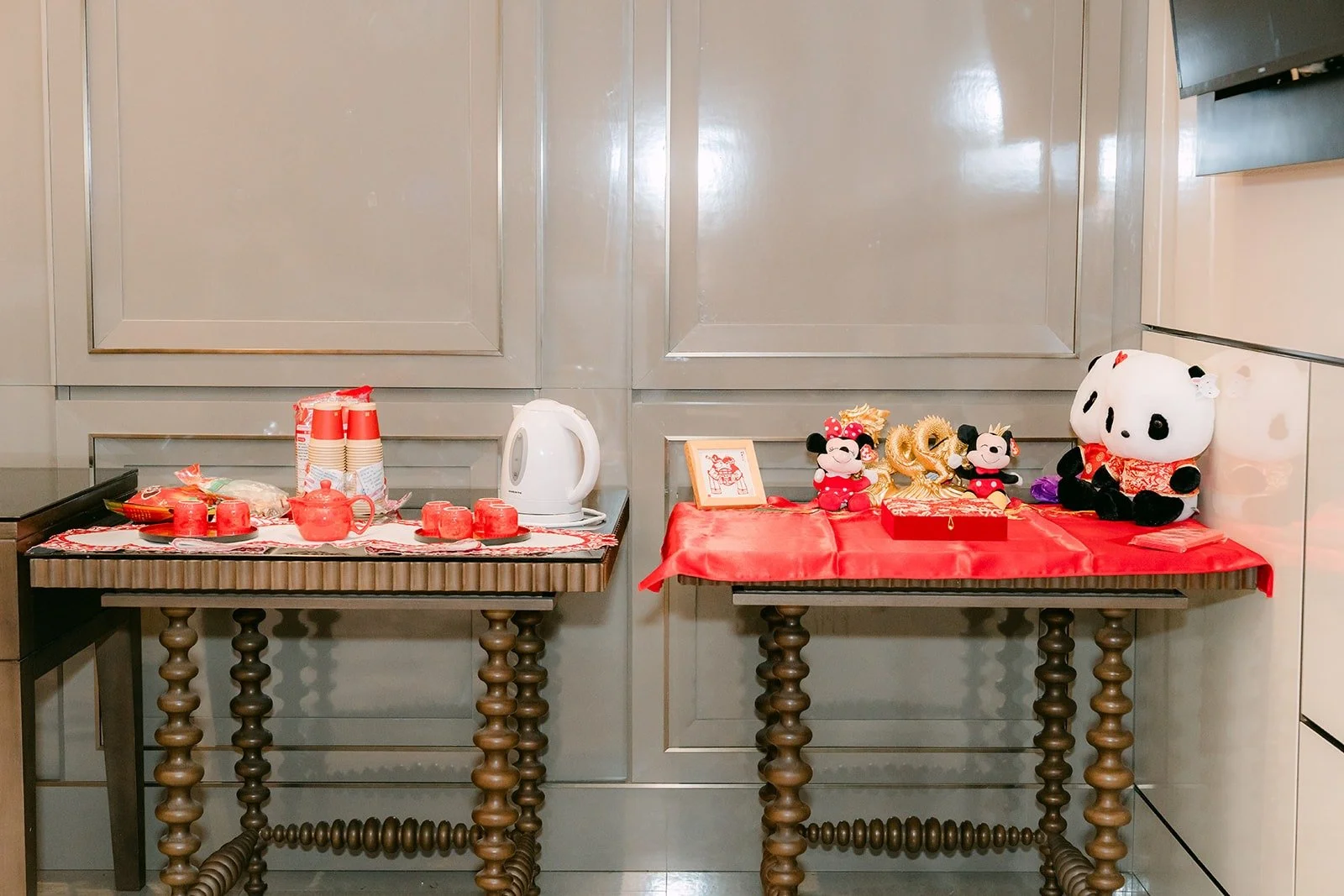 The tea ceremony table set with a red tea set, red cushions and a panda plush