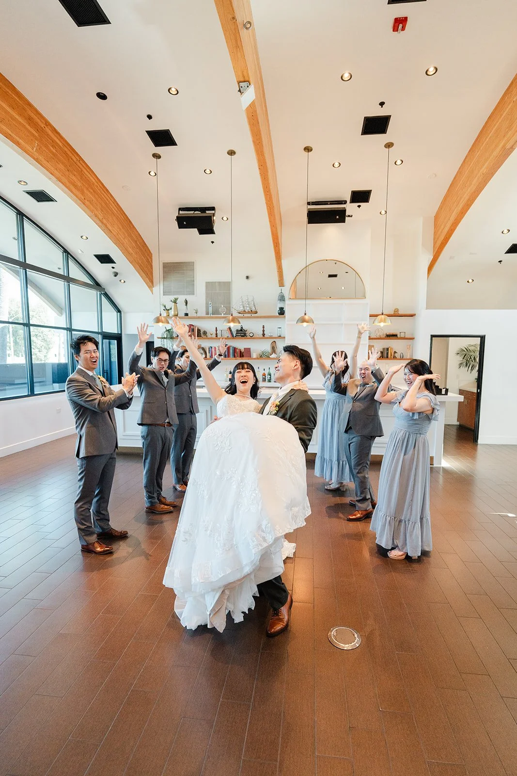 Wedding party walking toward the camera in the bright hall