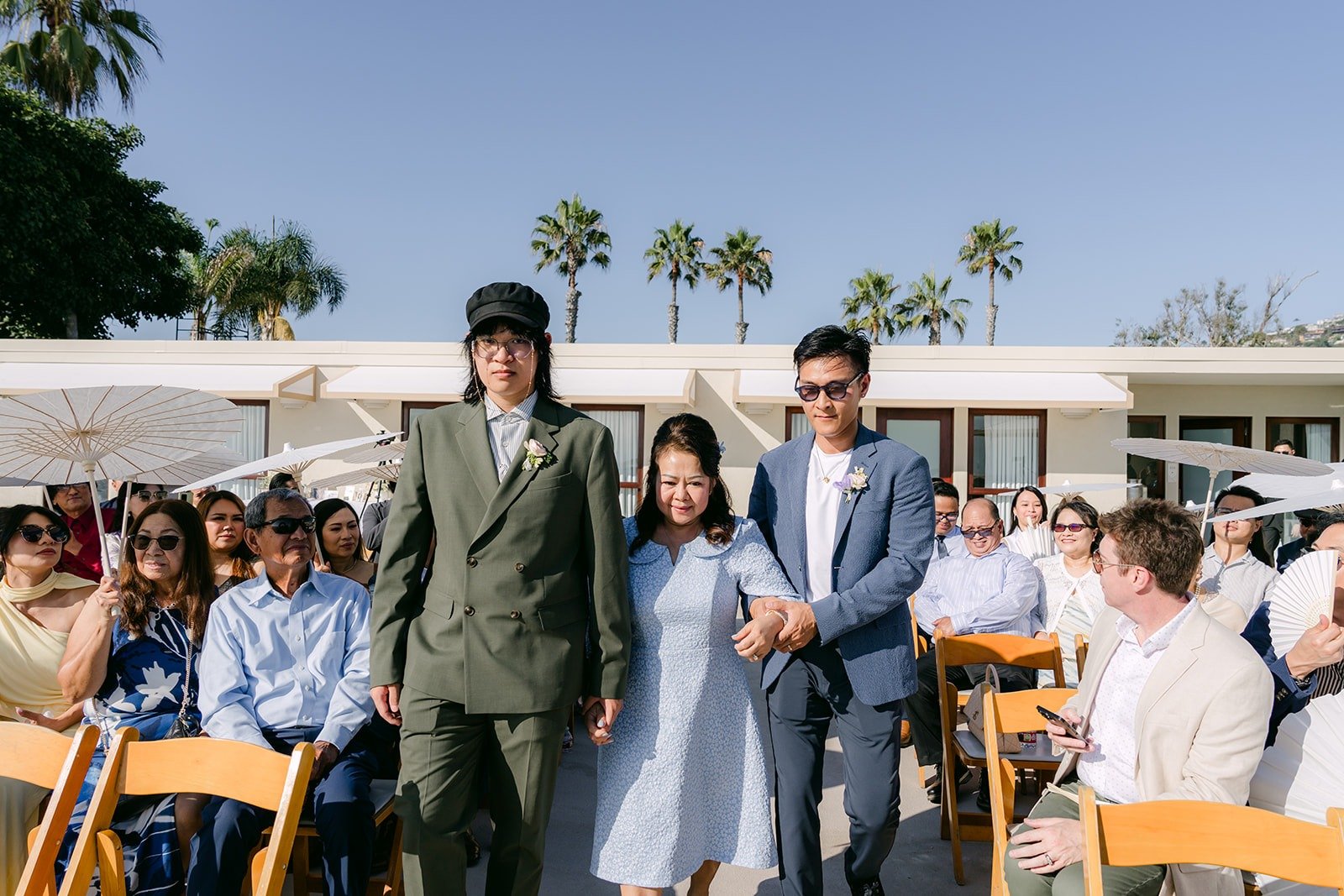 Family members walking down the aisle as guests watch
