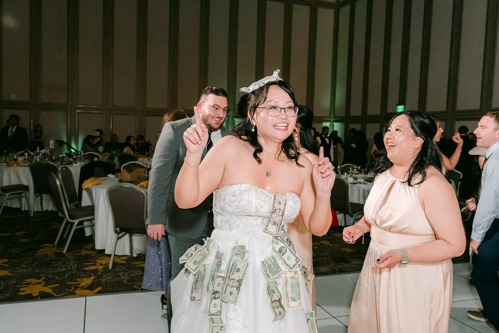 Stella in a crown with her dress covered in bills from the money dance