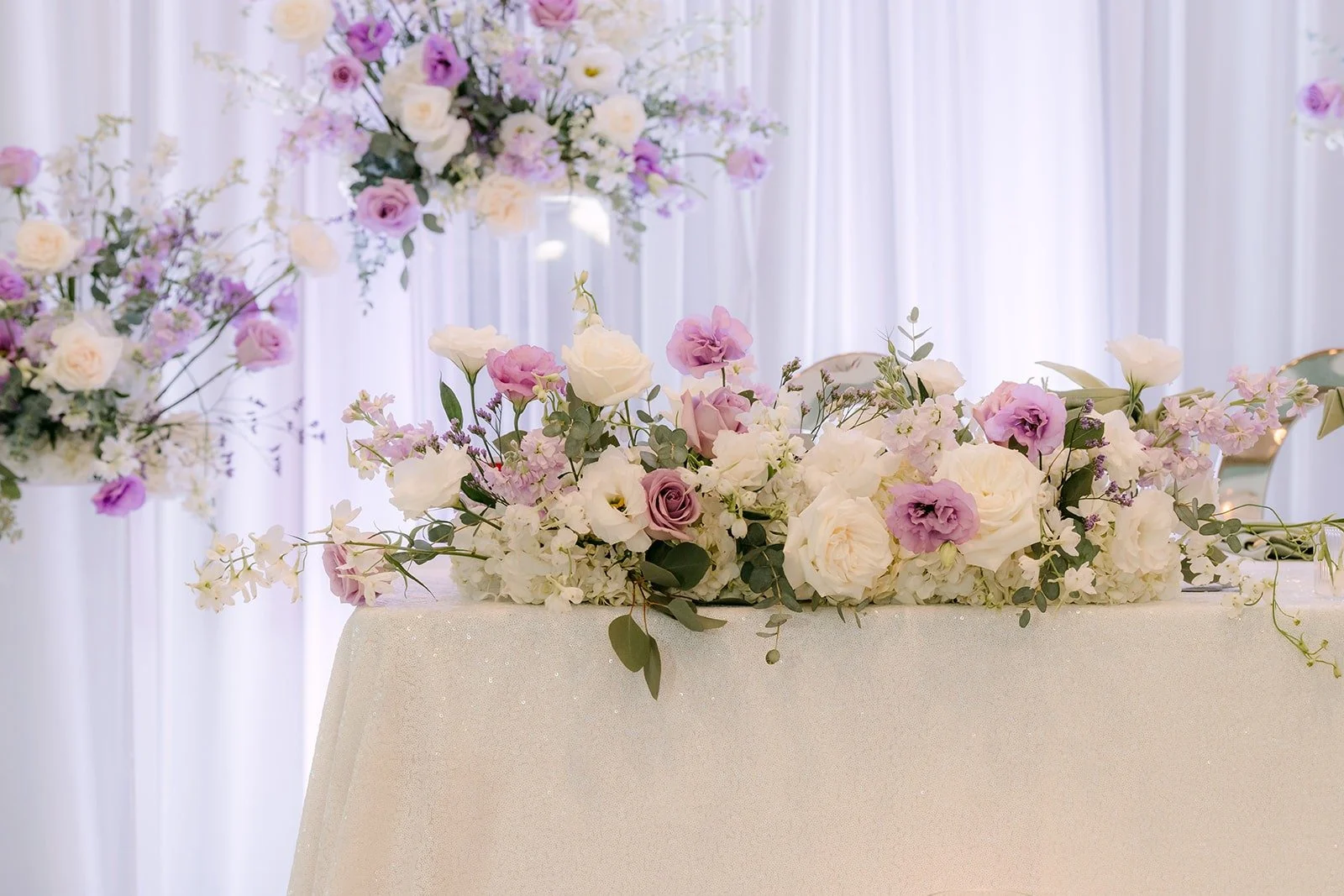 Lavender and white florals along the sweetheart table