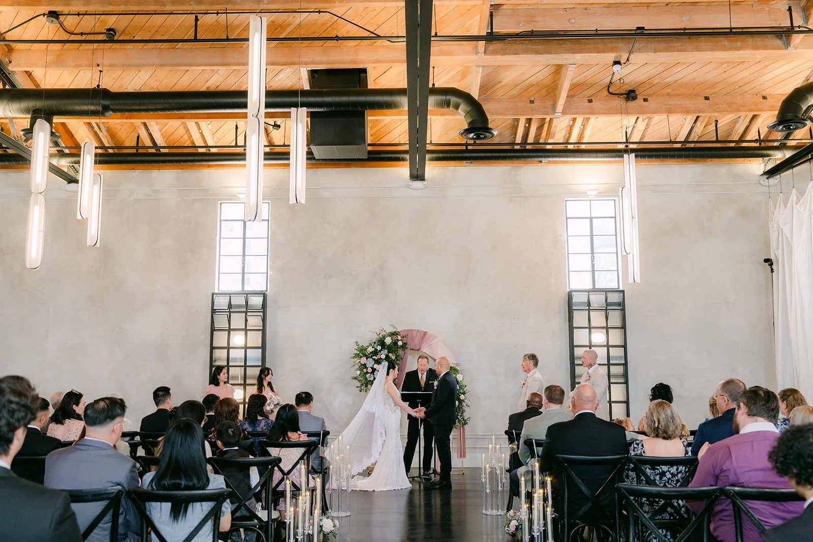 A wide view of the ceremony under the high windows at The Headquarters