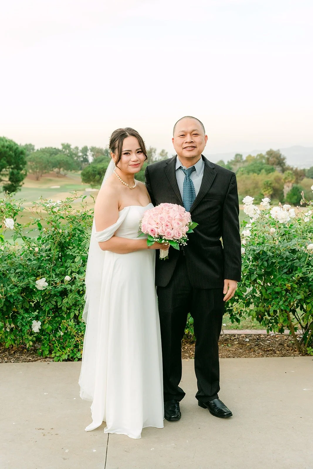 Ivy with a family member in front of the white roses
