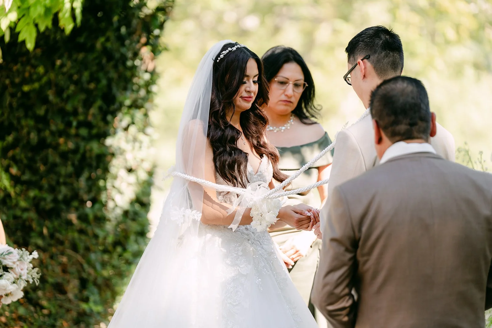 Sandra and Kevin facing the officiant under the pergola.