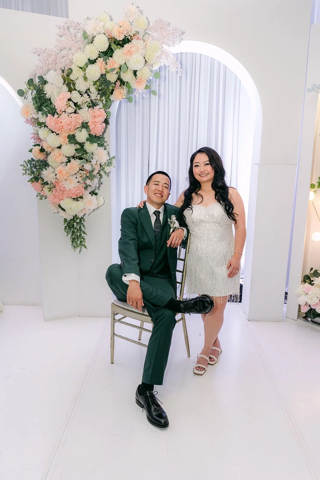 Kevin and Jennifer by the floral arch at the end of the night, photographed by One and Only Production