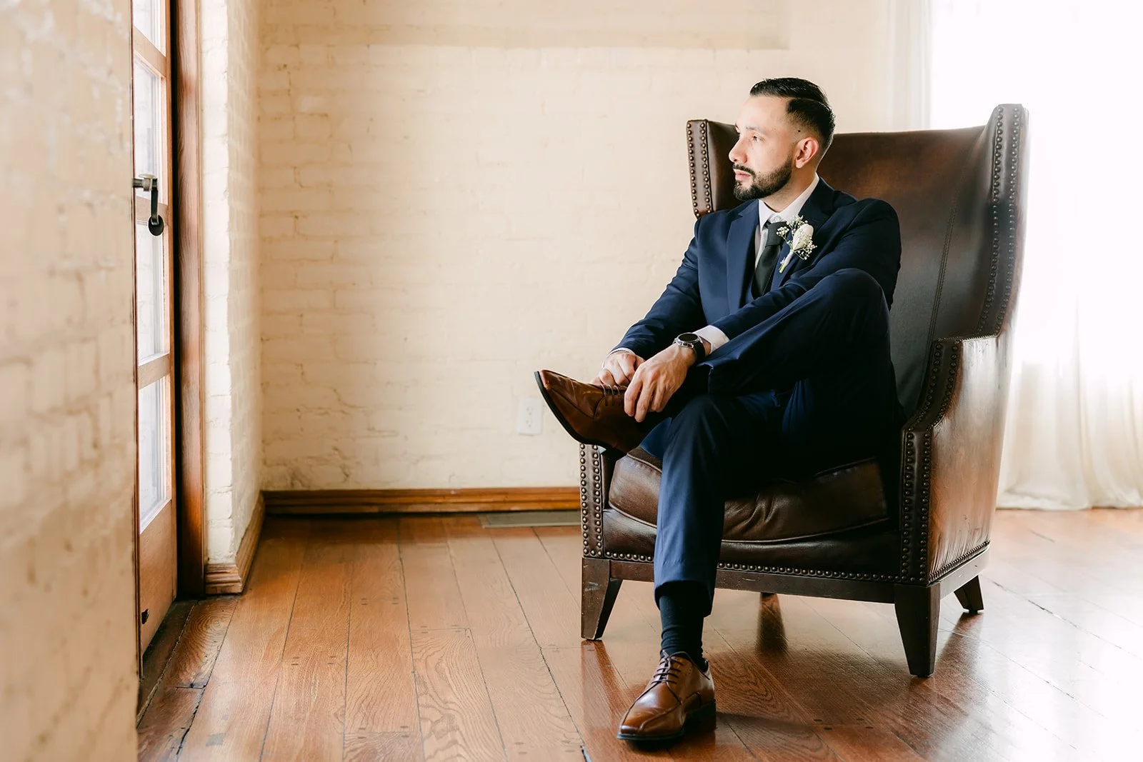 Danny seated in a leather wingback chair in the groom's room