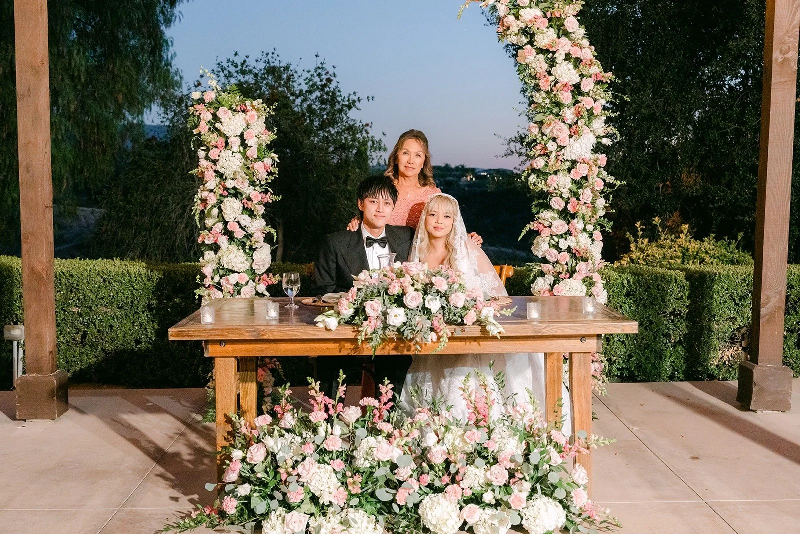 Konitha and Job at their sweetheart table framed by floral columns