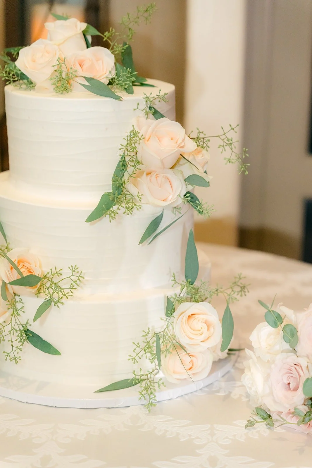Three tier white cake with blush roses
