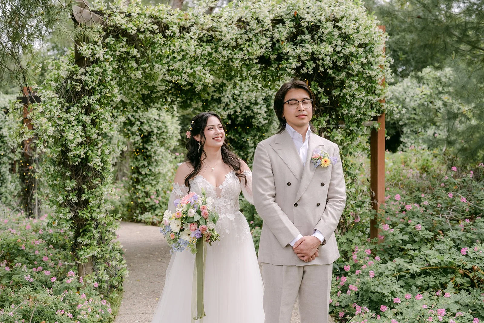 Kat and Mike smiling together in front of the ivy covered arch