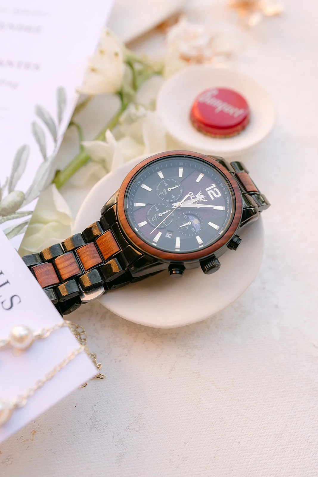 Cody's wooden watch beside the invitation suite.