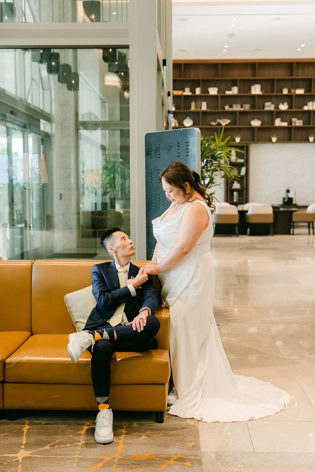 Mai and Bobby on a mustard sofa in the lobby.