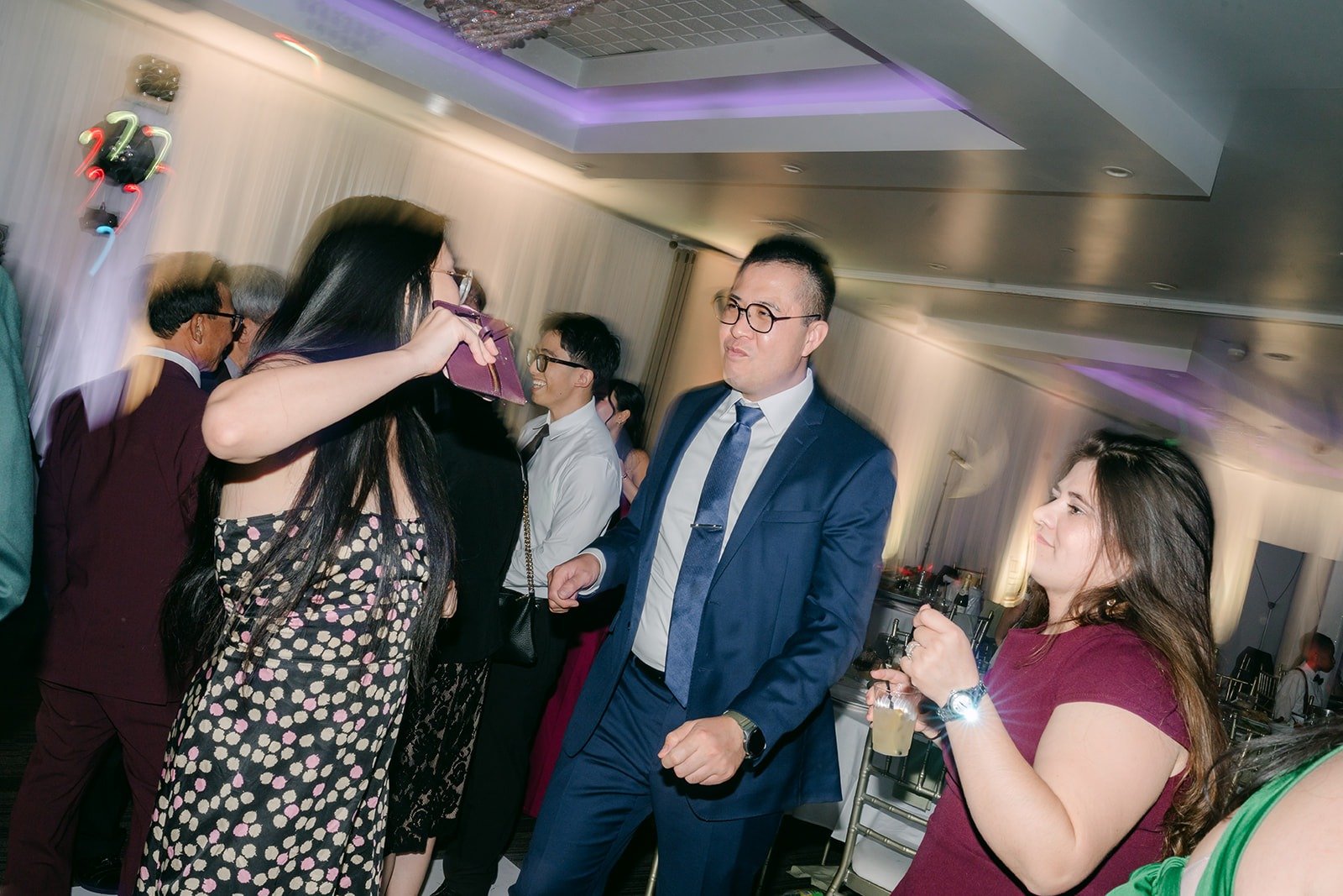 A groomsman dances with guests late in the night, photographed by One and Only Production