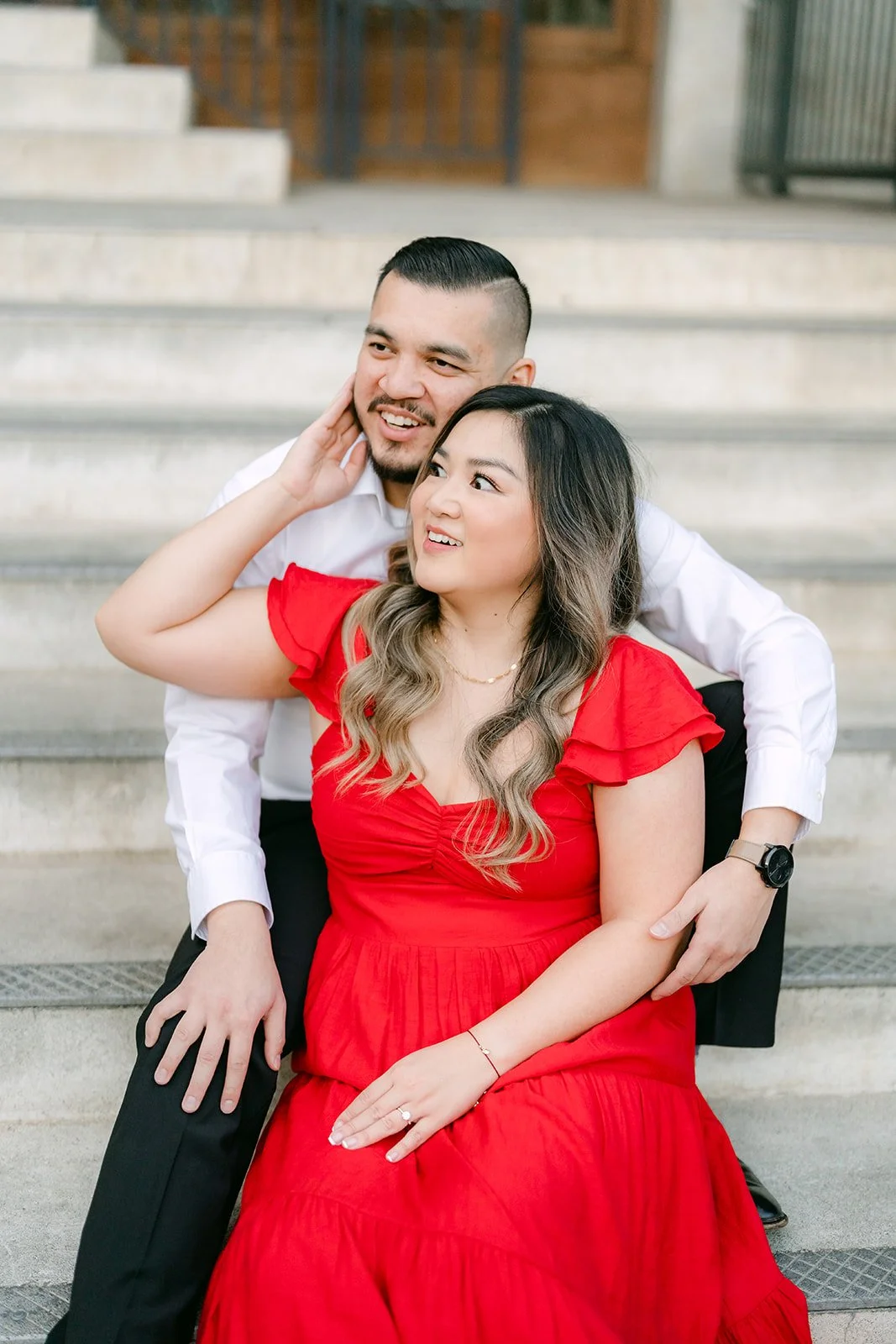 Ankush hugs Linh from behind on the stone steps.