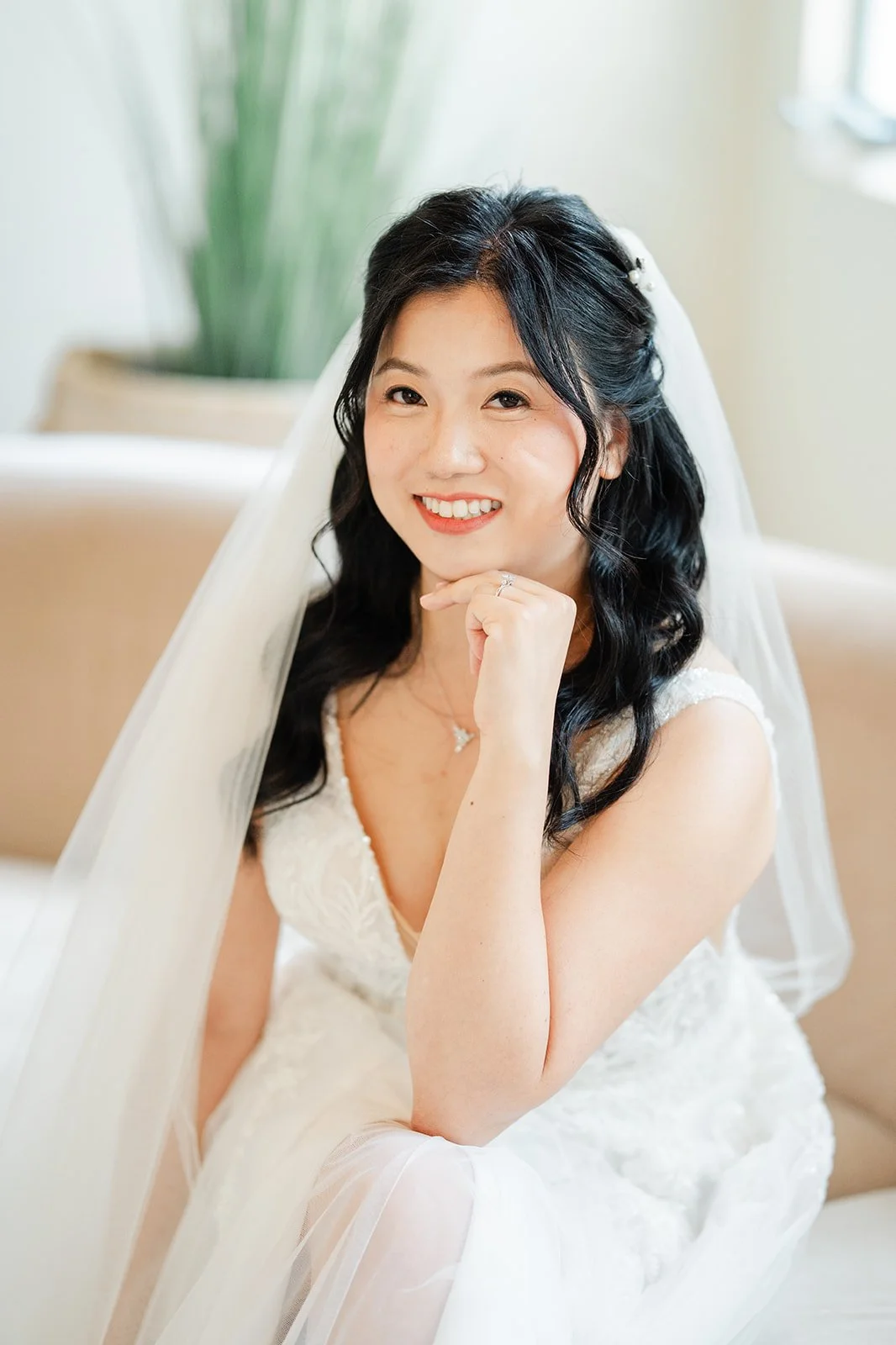 Bridal portrait of Constance smiling with her chin resting on her hand