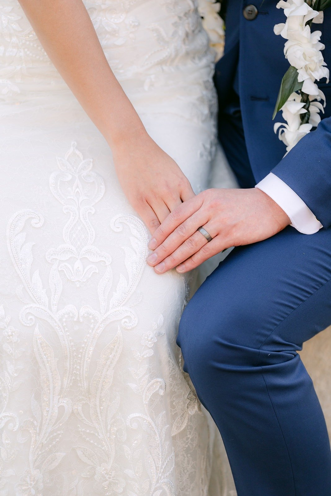 A close view of Kelli's ring as she rests her hand on Alex's knee