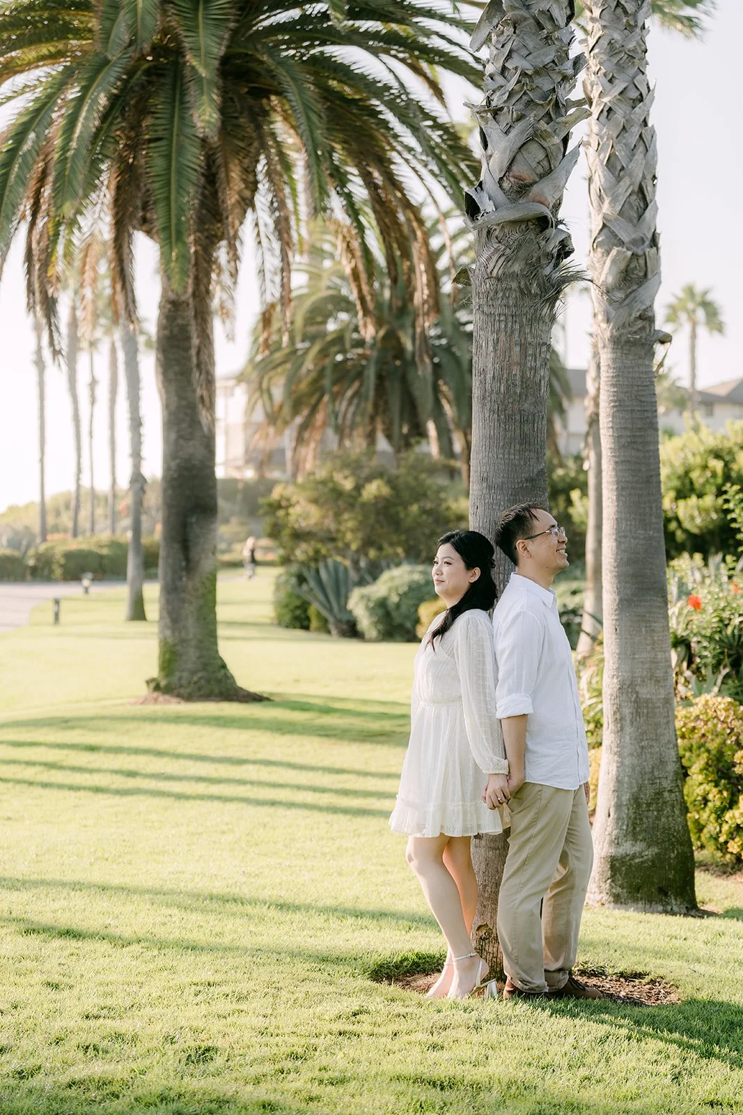 Constance and Lawrence on the grass beneath the palms.