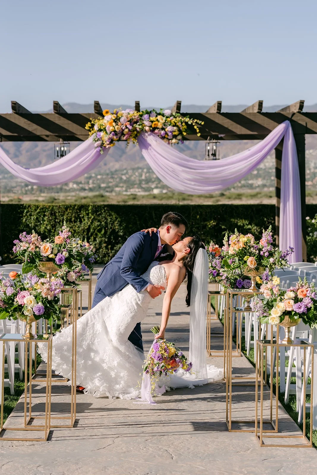 Elijah dipping Vannie under the pergola at the end of the aisle.