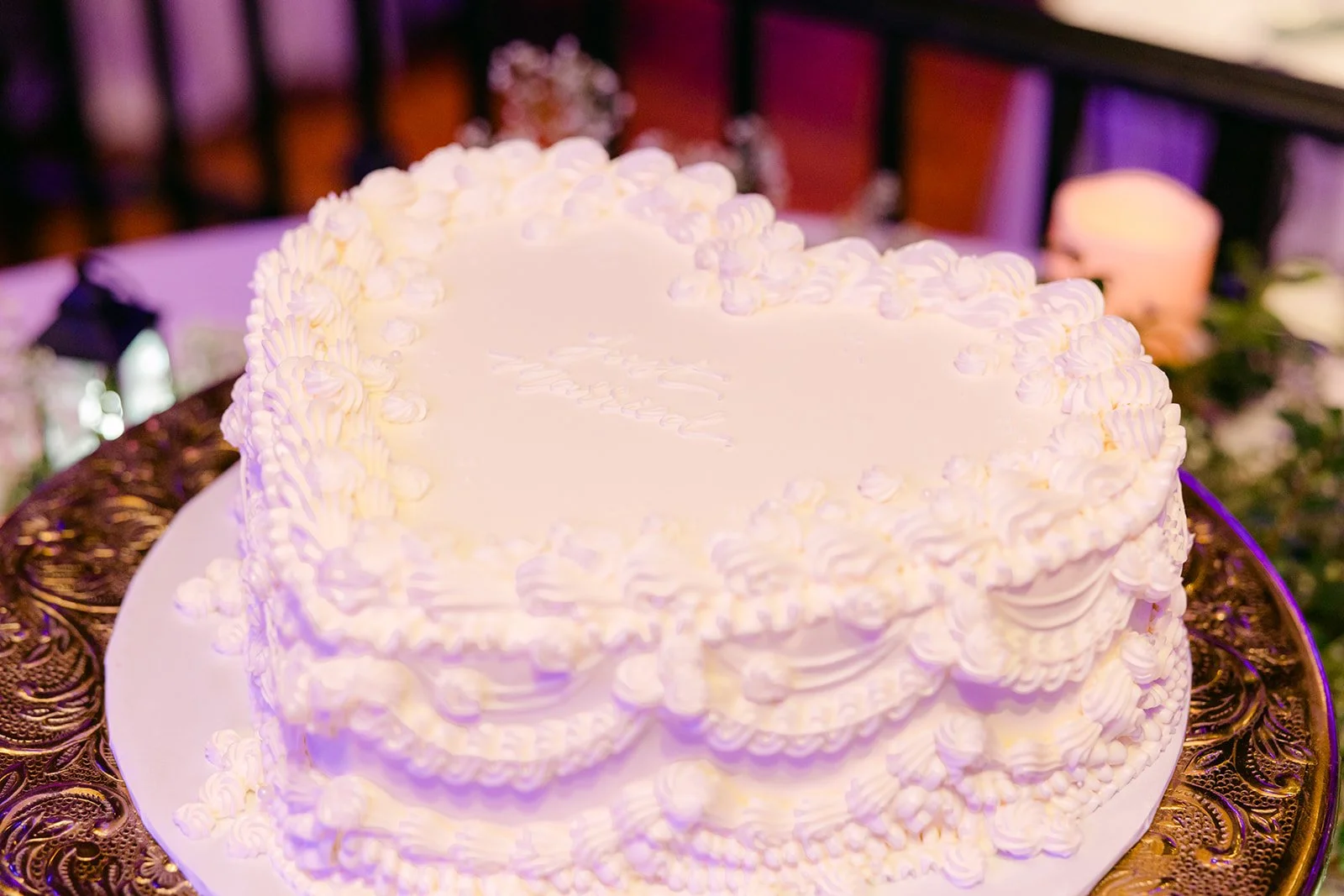 Close up of the white heart cake with piped vintage frosting
