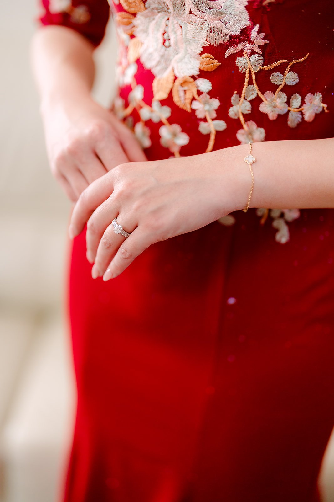 Pauline's hand resting on her embroidered qipao.