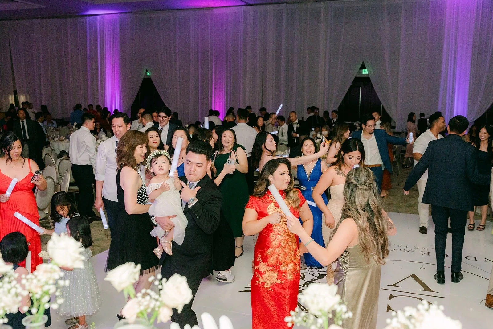 Guests dancing under purple lights in the San Gabriel Ballroom