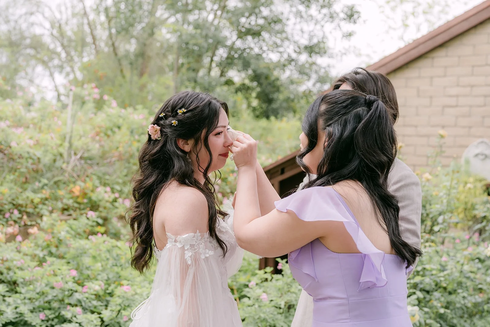 Bridesmaid in lavender adjusting Kat's hair in the garden