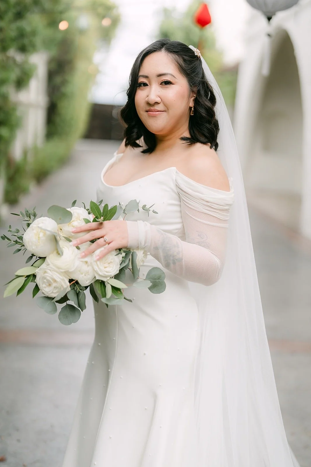 Vivian holding her white rose bouquet among red lanterns
