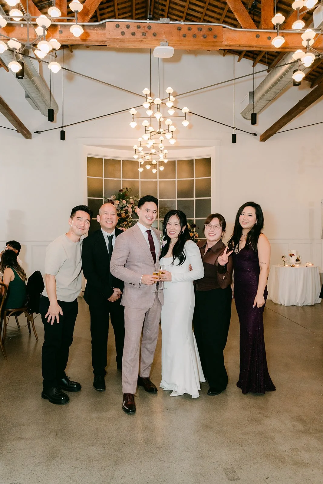 Denise and Michael with their wedding party under the chandeliers, photographed by One and Only Production.