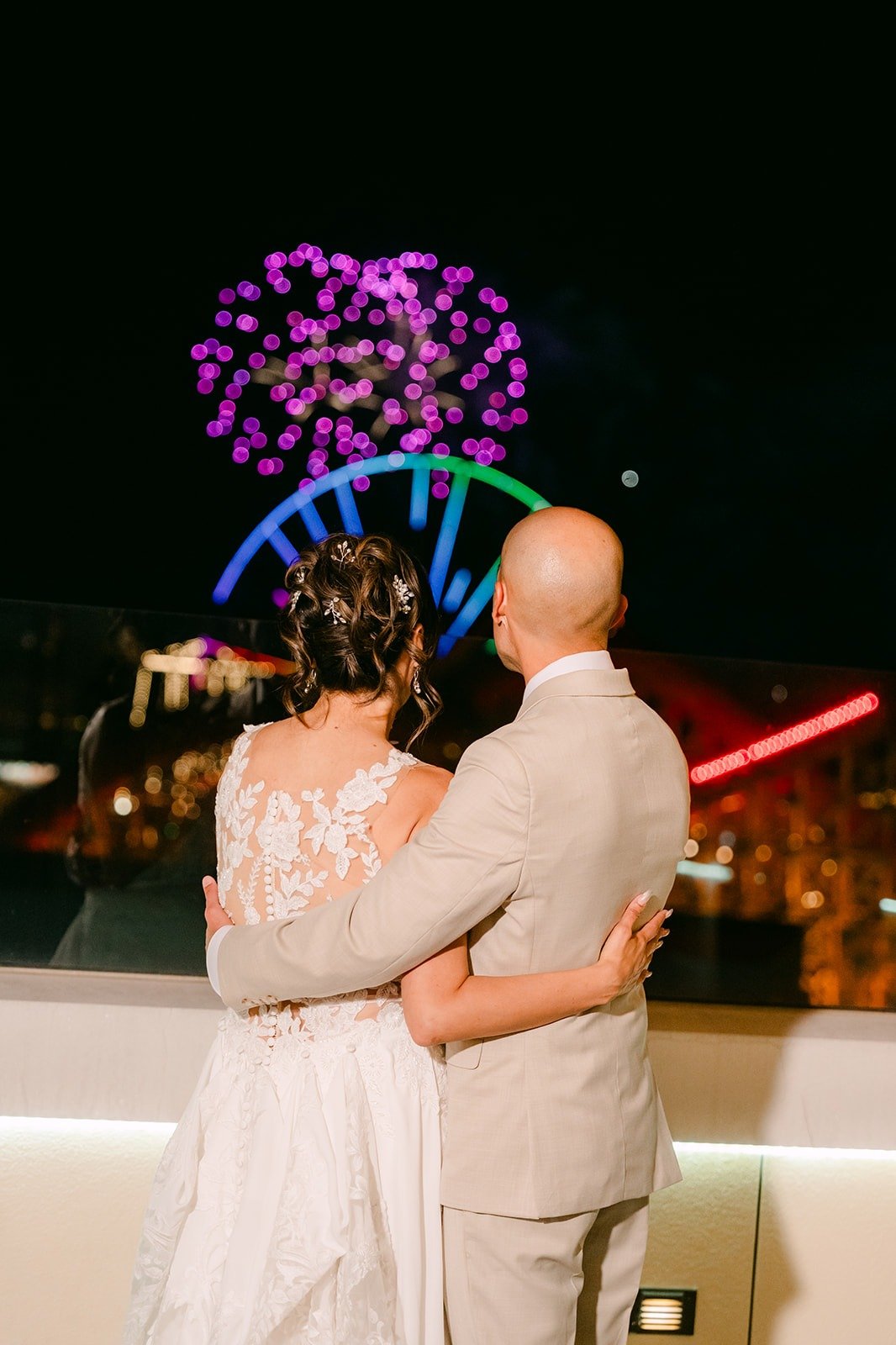 Francesca and Daniel watch purple fireworks light up the sky from the Jewel Terrace
