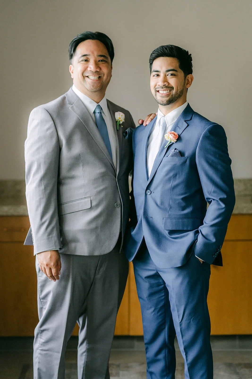Mark with a groomsman in a gray suit, both smiling for the camera