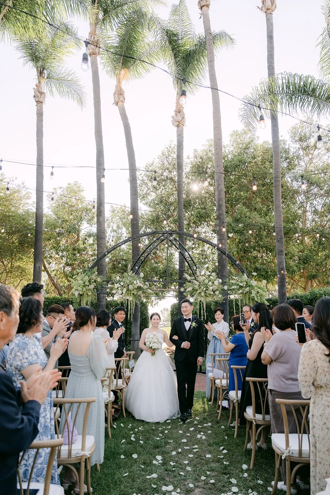 Wide view of the ceremony in the Italian Garden with palms overhead