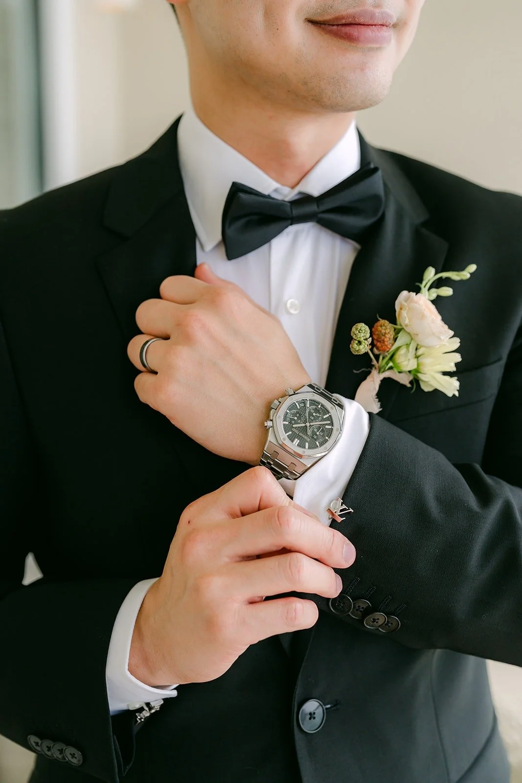 Mario adjusting his cuff, his watch and boutonniere in view
