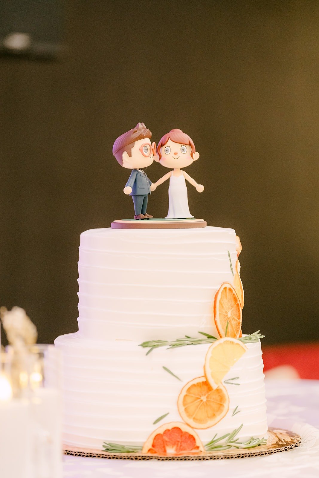 A cartoon couple cake topper on the white cake