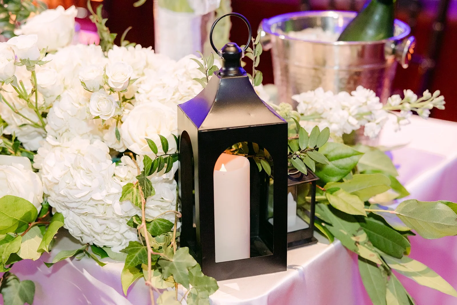 White hydrangea, roses and a black lantern centerpiece