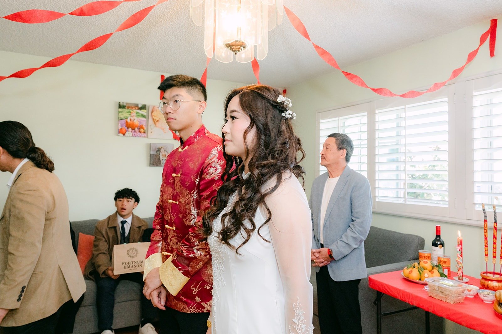 Robert in red and Shayna in white stand together between tea servings