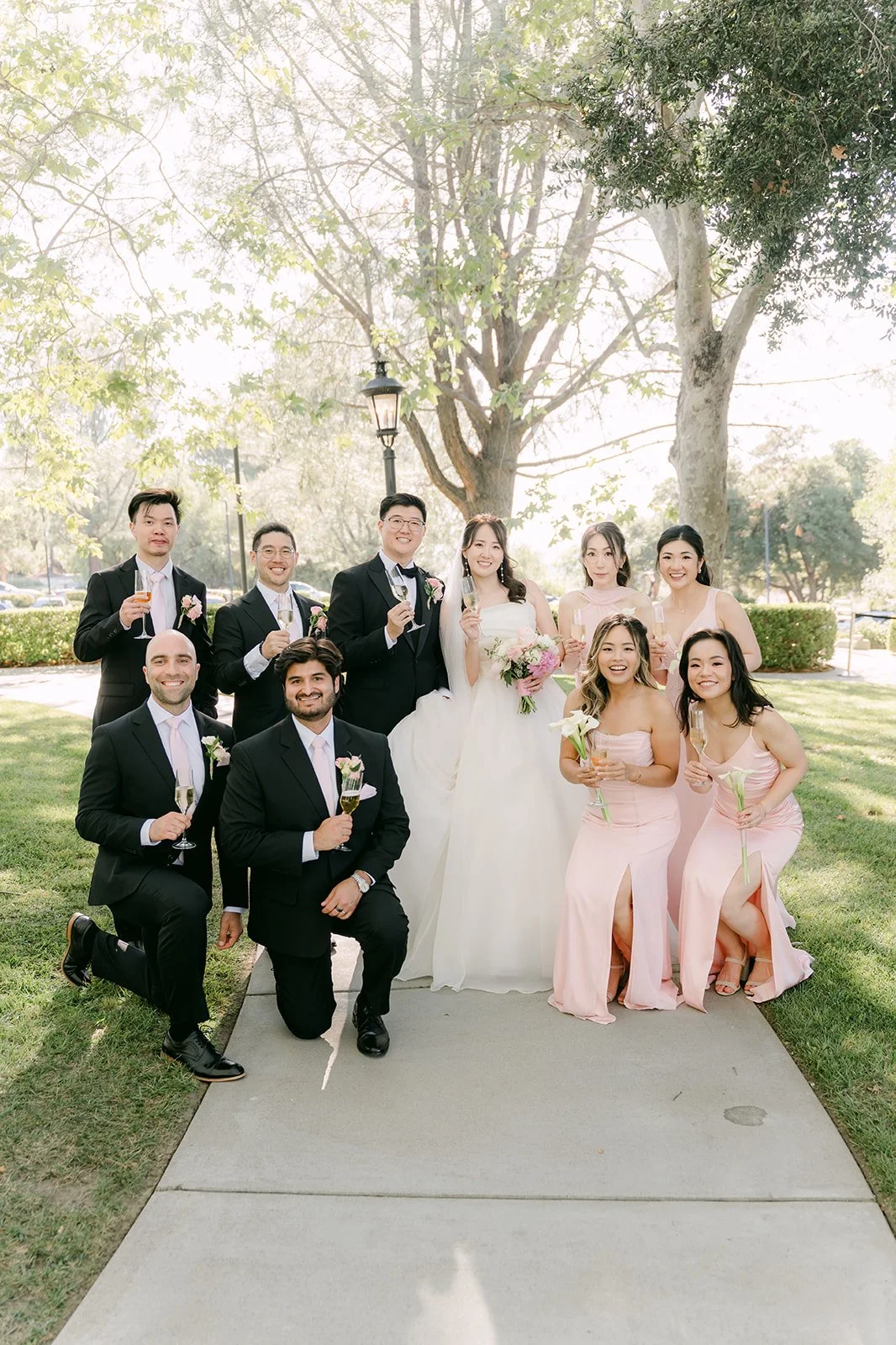Groomsmen kneeling in front of the bridesmaids
